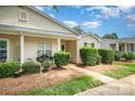 Inviting single-story home with a cozy front porch, manicured shrubs, and well-maintained landscaping at 5402 Harris Cove Dr, Charlotte, NC 28269