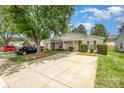 Charming one-story home showcasing a well-kept lawn, mature trees, and an extended driveway with ample parking at 5402 Harris Cove Dr, Charlotte, NC 28269