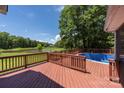 Backyard deck and pool area overlook a scenic pond with lush greenery and mature trees in the distance at 6504 Sybil Ct, Indian Trail, NC 28079