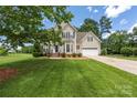 Attractive two-story home with a well-manicured lawn, attached garage, and classic architectural details at 6504 Sybil Ct, Indian Trail, NC 28079