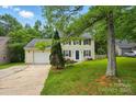 Inviting home with lush green lawn and mature trees providing shade and curb appeal at 8014 Sherington Way, Charlotte, NC 28227