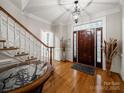 Welcoming foyer with hardwood floors, staircase, elegant lighting, and decorative accents at 8527 Foxbridge Dr, Matthews, NC 28104