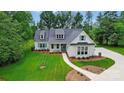 Stunning home features pristine landscaping, a walkway, blue shutters, and a charming covered porch at 9311 Simpson Rd, Waxhaw, NC 28173