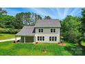 Back view of the home showcasing its well-manicured lawn and covered patio at 9315 Simpson Rd, Waxhaw, NC 28173