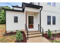 Inviting front entry featuring a craftsman door, stone accents, and freshly mulched landscaping at 1011 Sandy Ct, Gastonia, NC 28056