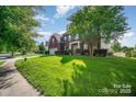Traditional brick home with lush landscaping and a spacious front yard on a sunny day at 10515 Greenhead View Rd, Charlotte, NC 28262
