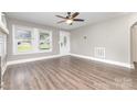 Bright living room with hardwood floors, ceiling fan, and large windows offering plenty of natural light at 1103 Oklahoma St, Kannapolis, NC 28083
