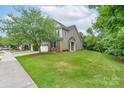 Landscaped front yard showing the exterior of this cozy townhome with well manicured lawn at 11945 Red Rust Ln, Charlotte, NC 28277