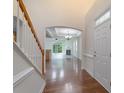 Inviting foyer with hardwood floors, staircase, and archway leading to the living area at 11945 Red Rust Ln, Charlotte, NC 28277