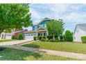 Beautiful blue two-story home with a well-kept lawn, inviting front porch and a two-car garage at 12107 Grey Partridge Dr, Charlotte, NC 28278