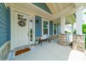 Inviting front porch featuring stone accents, decorative wreath, and a cozy seating area at 12107 Grey Partridge Dr, Charlotte, NC 28278