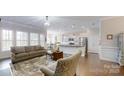Open-concept living room with hardwood floors, flows seamlessly into the kitchen and dining area at 123 Hanks Bluff Dr, Mooresville, NC 28117