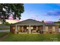 Relaxing covered brick patio with outdoor seating, ceiling fans, and a lush green lawn at 133 43Rd Avenue Nw Ln, Hickory, NC 28601