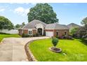 Charming brick home featuring a well-manicured lawn, landscaped front yard, and a paved driveway at 133 43Rd Avenue Nw Ln, Hickory, NC 28601