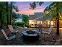 Inviting backyard with a stone fire pit and spacious deck, perfect for outdoor entertaining under string lights at 15301 Marsh Field Ct, Huntersville, NC 28078