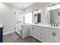 Elegant bathroom with a glass-enclosed shower, double vanity, marble countertops, and modern fixtures at 15301 Marsh Field Ct, Huntersville, NC 28078