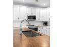 Modern kitchen with stainless steel appliances, wood countertops, a stylish faucet, and white cabinetry at 15301 Marsh Field Ct, Huntersville, NC 28078
