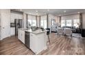 Open-concept kitchen with a large island, stainless steel appliances, and hardwood floors flowing into the living area at 1600 Baymont Ct, Stanley, NC 28164