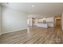 Large living room flows into a modern kitchen with white cabinets and stainless steel appliances at 1600 Baymont Ct, Stanley, NC 28164