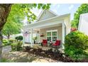 Home's inviting covered porch features cozy seating and a view of the manicured front yard at 19539 Denae Lynn Dr, Cornelius, NC 28031