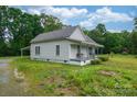 Exterior shot of a charming house with a covered front porch surrounded by lush greenery at 2126 Robby Dr, Maiden, NC 28650