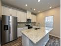Modern kitchen with stainless steel appliances, granite countertops, and a kitchen island at 2139 Rolling Hills Ct, Stanley, NC 28164