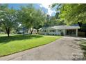 Inviting single-story home with a covered carport, lush lawn, and a view of the surrounding neighborhood at 3549 Woodleaf Rd, Charlotte, NC 28205