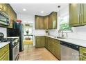 Inviting kitchen with stainless appliances, olive-green cabinets, and great natural light at 3708 Sweetgrass Ln, Charlotte, NC 28226