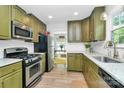Well-lit kitchen featuring stainless steel appliances and stylish olive-green cabinetry at 3708 Sweetgrass Ln, Charlotte, NC 28226