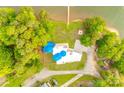 Aerial view of unique lake house with distinctive blue accents, a private dock, and verdant surroundings at 3911 Sandy Point Dr, York, SC 29745