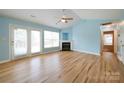 Bright living room with hardwood floors, fireplace, ceiling fan, and sliding glass doors to the outside at 4037 Lakota Ct, Charlotte, NC 28269