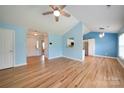 Open concept living room featuring hardwood floors, ceiling fan, and view into entry and kitchen at 4037 Lakota Ct, Charlotte, NC 28269
