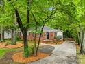 Inviting brick home with a patterned stone driveway and lush landscaping at 4114 Stacy Blvd, Charlotte, NC 28209