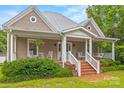 Inviting front porch with rocking chairs, hanging ferns, and a swing creates a relaxing outdoor space at 4569 Edgeland Rd, Edgemoor, SC 29712