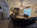 Comfortable living room showcasing a stone fireplace, large window, and neutral decor, complemented by a leather sectional sofa at 490 Deberry Rd, Mount Gilead, NC 27306