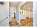 Bright hallway with hardwood floors leading to the kitchen and living areas at 509 Selkirk Pl, Charlotte, NC 28270