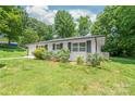 An exterior view of a single-story home with a well-manicured lawn, landscaping, and white brick at 518 Westside Cir, China Grove, NC 28023