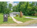 Landscaped front yard with a charming walkway leading to the front door and exterior mailbox at 518 Westside Cir, China Grove, NC 28023