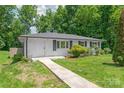 Well-maintained home featuring a concrete walkway, white exterior and lush lawn at 518 Westside Cir, China Grove, NC 28023