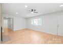 Light-filled living room boasts ceiling fan, white walls, and new floors at 518 Westside Cir, China Grove, NC 28023