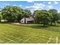 An aerial view of the property showcases the home, fenced yard, and surrounding greenery at 5200 Winding Ln, Indian Trail, NC 28079