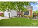 Well-maintained front yard with lush green grass and colorful landscaping leading to the home's entrance at 8410 Darcy Hopkins Dr, Charlotte, NC 28277