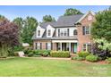 Inviting two-story brick home with a lush front lawn and mature trees at 9000 Petunia Ct, Gastonia, NC 28056