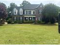 Charming two-story brick home with a well-manicured lawn and mature trees at 9000 Petunia Ct, Gastonia, NC 28056