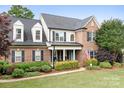 Traditional two-story brick home with well-manicured lawn and patriotic American flag at 9000 Petunia Ct, Gastonia, NC 28056