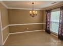 Traditional dining room with chandelier, trim, large window, and neutral wall paint at 9237 Bellegarde Dr, Charlotte, NC 28277