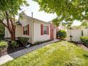 This exterior view shows the side yard, red shutters, brick detail, and well-maintained landscaping at 9360 Meadowmont View Dr, Charlotte, NC 28269