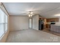 Open living area with carpet, ceiling fan, and views of the kitchen at 105 Peridot Dr, Statesville, NC 28625