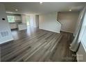 Bright living room featuring stairs and an open floorplan to the kitchen with wood-look flooring at 110 Browband St, Troutman, NC 28166