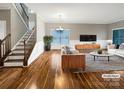 Bright living room showcases hardwood floors, a staircase, large windows and neutral wall colors at 110 Colville Rd, Mooresville, NC 28117
